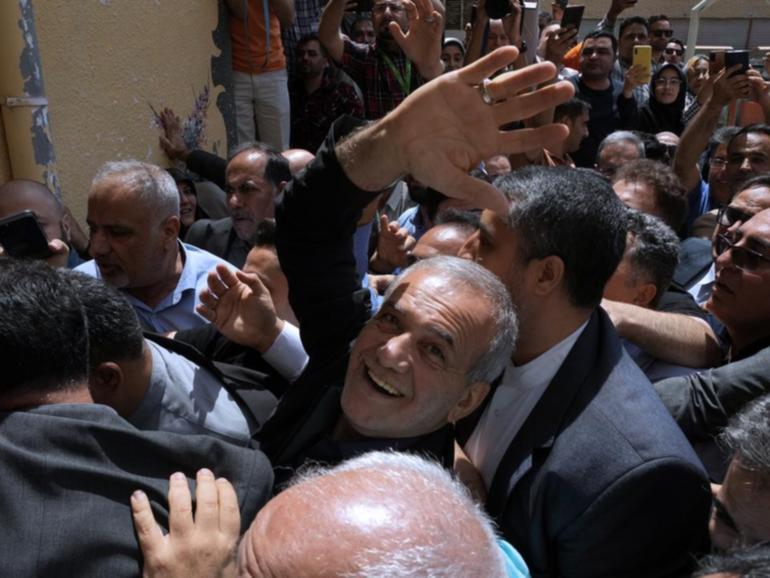 Masoud Pezeshkian (centre) has been declared the winner of Iran's presidential election.  (AP PHOTO)