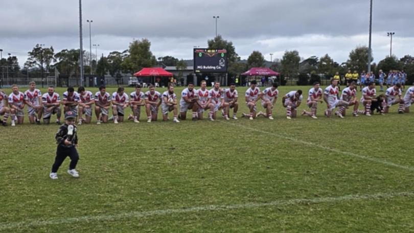 Woy Woy players take a knee before a game in a stand against racism.