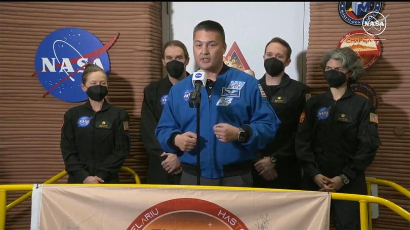 NASA Deputy Director Flight Missions Kjell Lindgren, centre, speaks in front of the crew members of the first CHAPEA mission, from left to right, Kelly Haston, Ross Brockwell, Nathan Jones, and Anca Selariu, after they emerged from their craft.