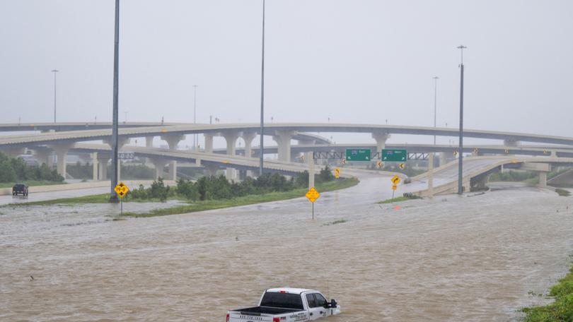 A vehicle is left abandoned in floodwater on a Houston highway after Hurricane Beryl swept through the area.