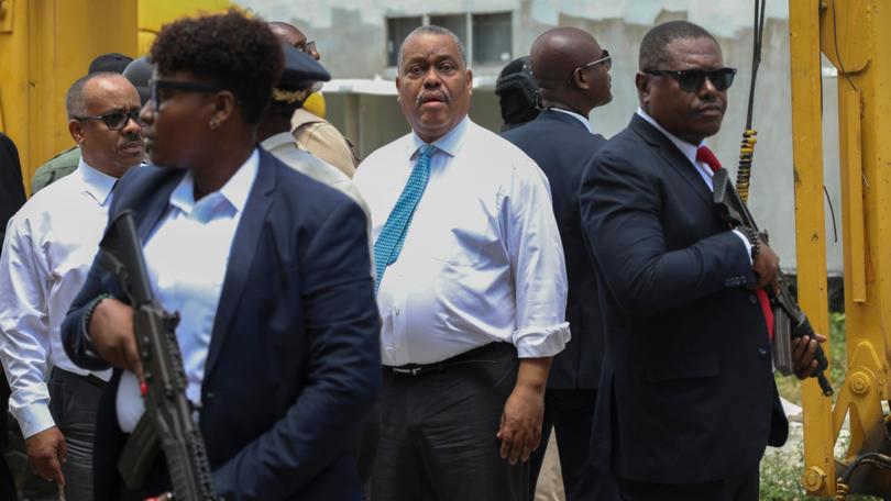 Security surrounds Haitian Prime Minister Garry Conille, centre, as he arrives at the General Hospital in Port-au-Prince.