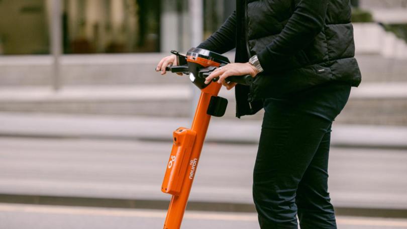 A person riding a Neuron electric scooter