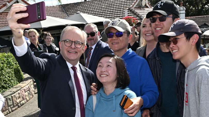 Prime Minister Anthony Albanese poses for selfies  with supporters at the Mount Coot-tha Lookout in Brisbane.