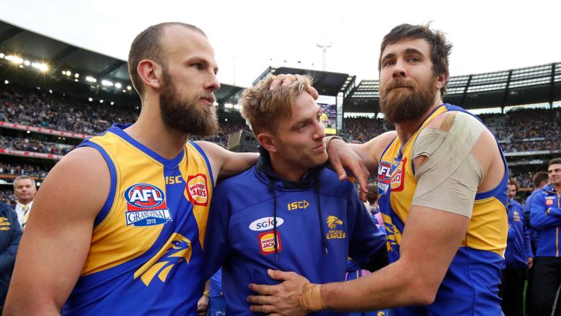 Brad Sheppard is consoled by Will Schofield (left) and Josh Kennedy of during the 2018 AFL grand final. 