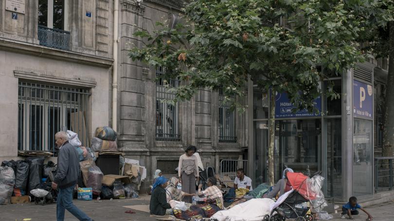 Homeless people on a sidewalk by City Hall in Paris on July 1.