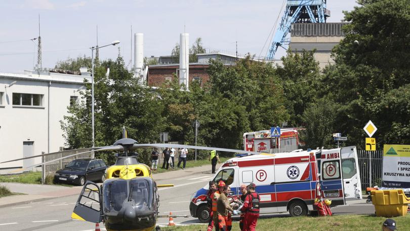 Rescuers transport an injured miner to an airborne ambulance near the Rydultowy coal mine near the city of Rybnik, in southern Poland,