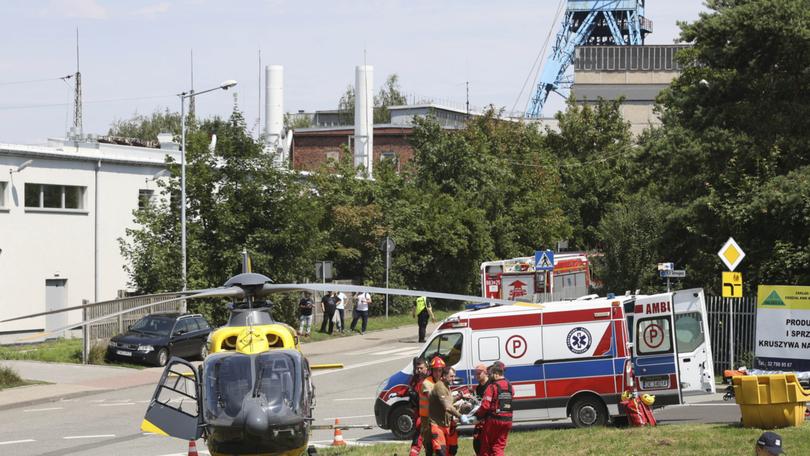 Rescuers transport an injured miner to an airborne ambulance near the Rydultowy coal mine near the city of Rybnik, in southern Poland, 