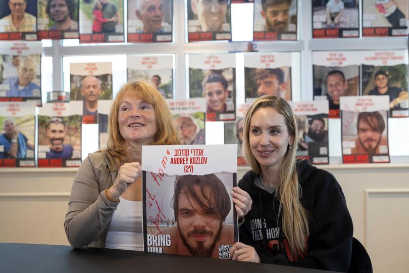 Evgeniia Kozlova, mother of Andrey Kozlov, and Jenifer Master, the girlfriend of Andrey Kozlov, hold a poster with his picture after his rescue.