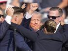 Republican presidential candidate former President Donald Trump is helped off the stage at a campaign event in Butler, Pa., on Saturday, July 13, 2024. (AP Photo/Gene J. Puskar)