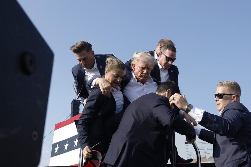 Donald Trump is helped from the stage. 