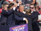 Former President Donald Trump is helped off the stage after the assassination attempt. 