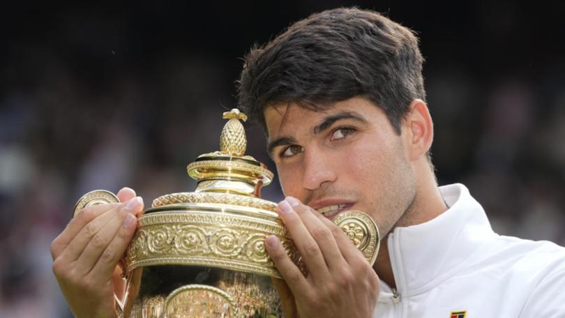 Carlos Alcaraz clutches the Wimbledon men's singles trophy again after a fabulous win.