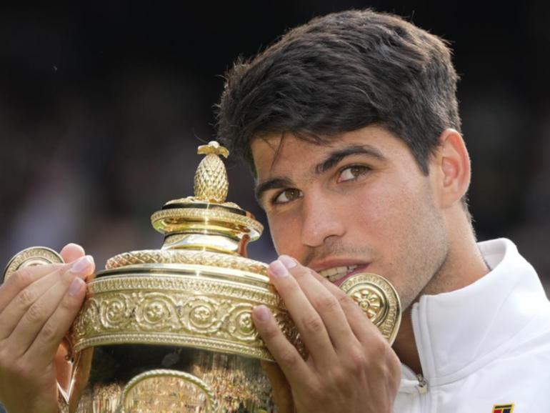 Carlos Alcaraz clutches the Wimbledon men's singles trophy again after a fabulous win.