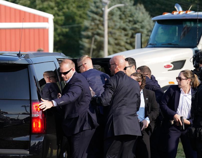 Members of the Secret Service assist former President Donald Trump into a vehicle on Saturday. 