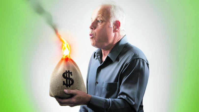 Senior man trying to blow out bag of money on fire