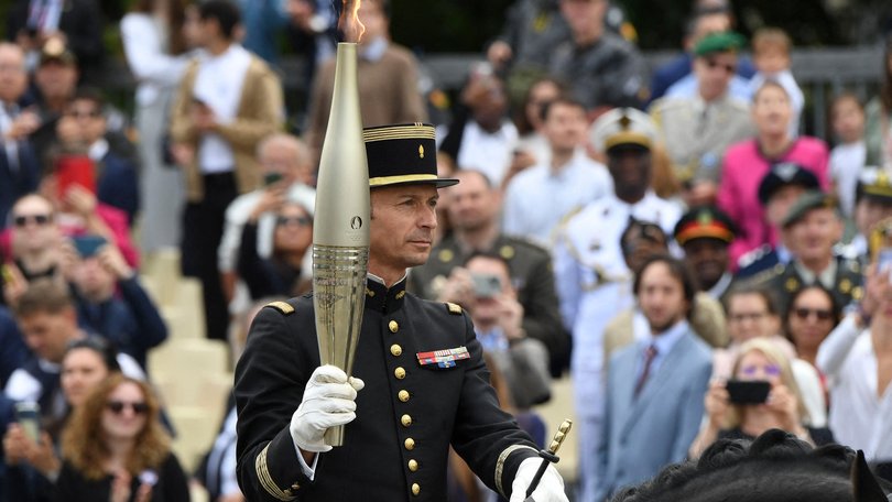 Head of the Cadre Noir de Saumur squires and gold medallist in Rio in 2016 Thibaut Vallette holds the Olympic flame torch on a horse during the Bastille Day parade.