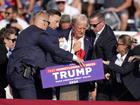 Donald Trump is helped off the stage after the shooting.