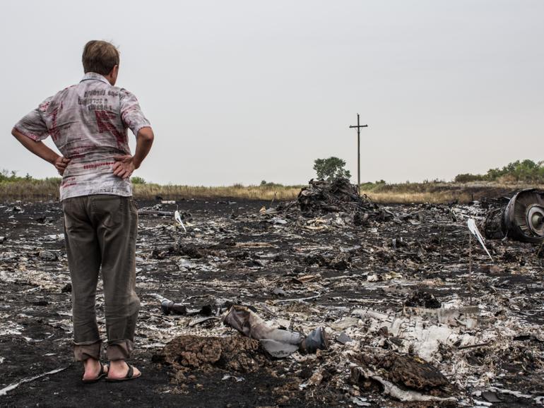 A man looks at debris from MH17 on July 18, 2014.