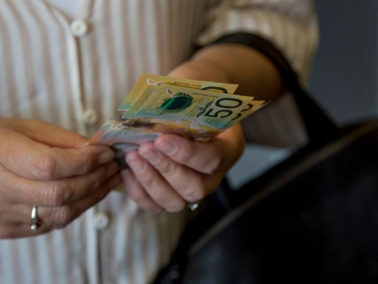 A person holding cash. File image