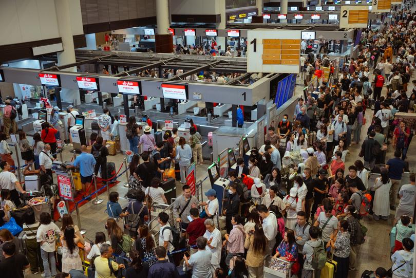 BANGKOK, THAILAND - JULY 20: Queues of passengers remain at the Air Asia check-in counters at Don Mueang Airport international departures on July 20, 2024 in Bangkok, Thailand. A significant global outage affecting Microsoft services, particularly Microsoft 365, has caused widespread disruptions across various sectors, including airlines, banks, and health systems. The outage was attributed to a glitch in CrowdStrike's "Falcon Sensor" software, which impacted Windows systems, leading to thousands of flight cancellations and operational chaos in multiple industries. Microsoft has reported that the underlying cause of the outage has been fixed, but residual effects continue to impact some users as the company works on full recovery. (Photo by Mailee Osten-Tan/Getty Images) ***BESTPIX***