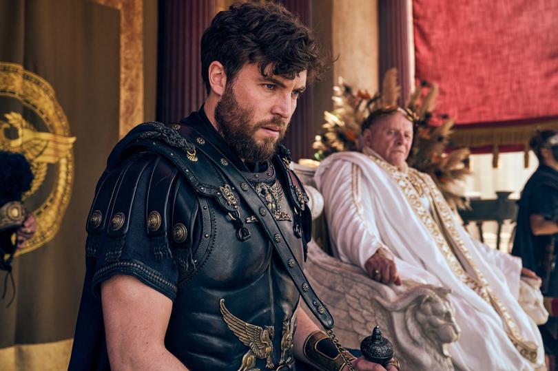 THOSE ABOUT TO DIE -- Episode 101  Pictured: (l-r) Tom Hughes as Titus, Anthony Hopkins as Emperor Vespasian  -- (Photo by: Reiner Bajo/Peacock)