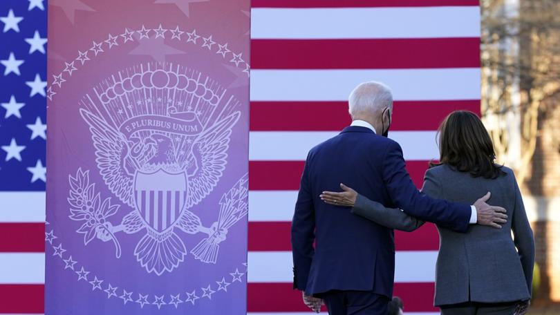 President Joe Biden and Vice President Kamala Harris walk off stage after speaking at an event. 