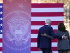 President Joe Biden and Vice President Kamala Harris walk off stage after speaking at an event. 