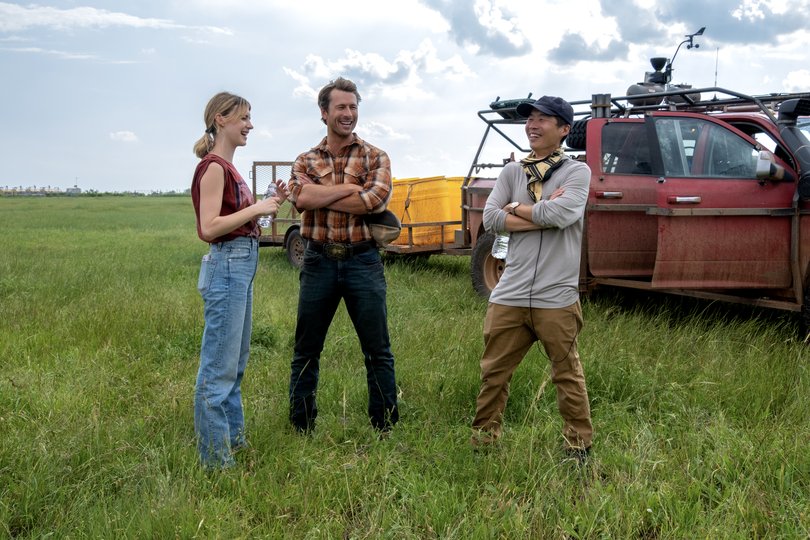 Twisters stars Daisy Edgar-Jones, Glen Powell with director Lee Isaac Chung on set.