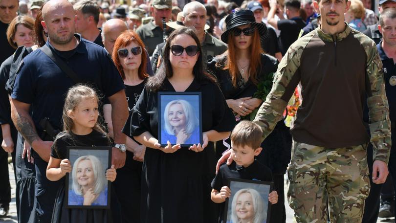 Relatives of Ukrainian former MP Iryna Farion carry her photos during her funeral procession in Lviv.