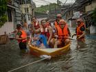 Manila Residents trapped by flooding caused by Typhoon Gaemi and monsoon rains ride a boat to safety.