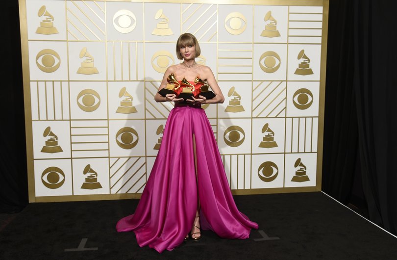 Taylor Swift poses in the press room with the awards for album of the year for 1989, pop vocal album for 1989 and best music video for Bad Blood at the 2016 Grammy Awards.