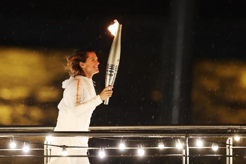 PARIS, FRANCE - JULY 26: French tennis player Amelie Mauresmo carries the  torch during the opening ceremony of the Olympic Games Paris 2024 on July 26, 2024 in Paris, France. (Photo by Richard Pelham/Getty Images)