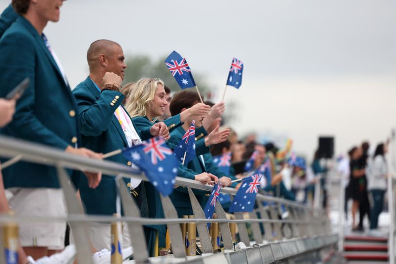 PARIS, FRANCE - JULY 26: Athletes of Team Australia wave flags on the team boat on the River Seine during the opening ceremony of the Olympic Games Paris 2024 on July 26, 2024 in Paris, France. (Photo by Quinn Rooney/Getty Images)