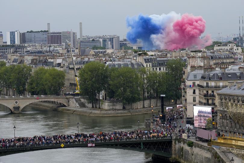 PARIS, FRANCE - JULY 26: Smoke in the colors of the France flag are set off as people gather on a bridge over the Seine River at the Opening Ceremony of the Olympic Games Paris 2024 on July 26, 2024 in Paris, France. (Photo by Bernat Armangue - Pool/Getty Images)