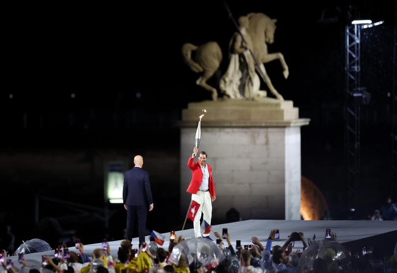 PARIS, FRANCE - JULY 26: Former footballer Zinedine Zidane looks on as Rafael Nadal of Team Spain carries the torch during the opening ceremony of the Olympic Games Paris 2024 on July 26, 2024 in Paris, France. (Photo by Hector Vivas/Getty Images)