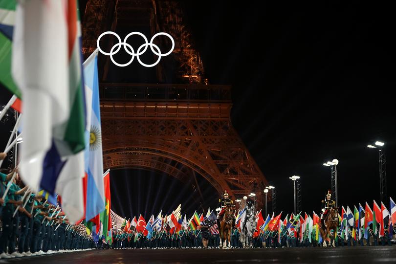 PARIS, FRANCE - JULY 26: A general view as The Horsewoman crosses the Iena Bridge to the Place du Trocadero, as Flags of Competing Nations are presented, as the Olympic Rings are seen on the Eiffel Tower during the opening ceremony of the Olympic Games Paris 2024 on July 26, 2024 in Paris, France. (Photo by Ryan Pierse/Getty Images)