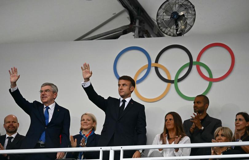 PARIS, FRANCE - JULY 26: France's President Emmanuel Macron (R) and the President of the International Olympic Committee (IOC) Thomas Bach wave as they arrive to attend the opening ceremony of the Paris 2024 Olympic Games 2024 on July 26, 2024 in Paris, France. (Photo by Loic Venance - Pool/Getty Images)