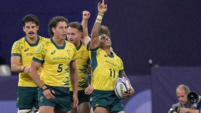 Australia’s rugby seven players celebrate after winning the quarter-final rugby against the USA.