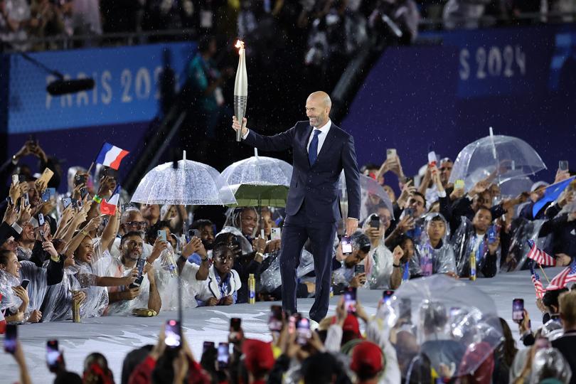 PARIS, FRANCE - JULY 26: Former footballer Zinedine Zidane carries the torch during the opening ceremony of the Olympic Games Paris 2024 on July 26, 2024 in Paris, France. (Photo by Hector Vivas/Getty Images)