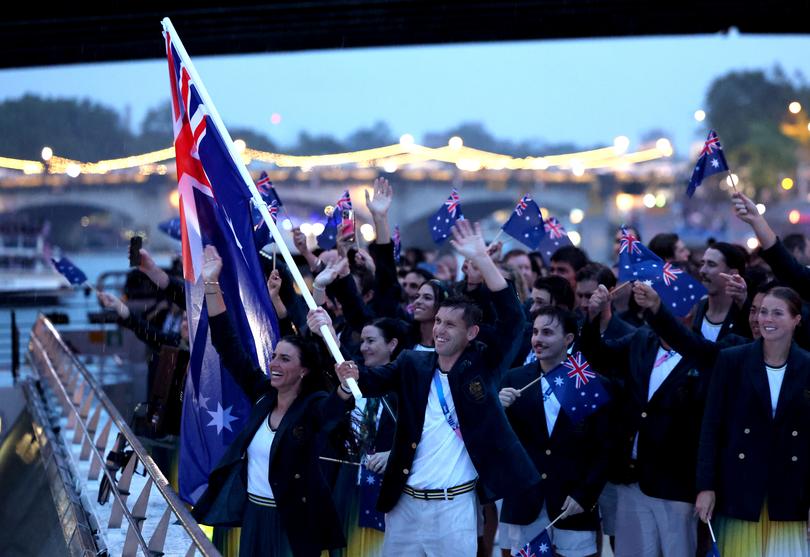 PARIS, FRANCE - JULY 26: Jessica Fox and Eddie Ockenden, Flagbearers of Team Australia, wave the flag on the athletes' parade team boat along the River Seine during the opening ceremony of the Olympic Games Paris 2024 on July 26, 2024 in Paris, France. (Photo by Quinn Rooney/Getty Images)