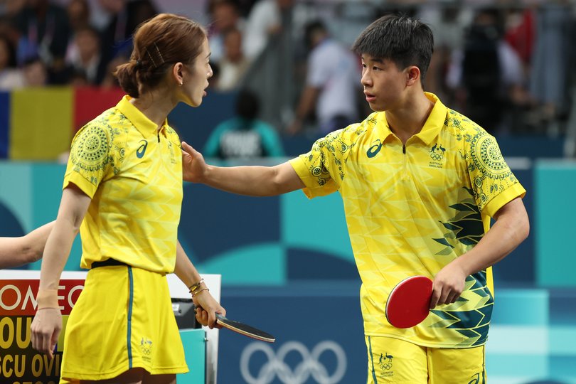 Minhyung Jee of Team Australia talks with teammate Nicholas Lum during a Mixed Doubles Round of 16 match against Team Romania.