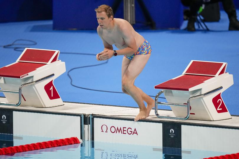 A lifeguard jumps into the competition pool to retrieve United States swimmer Emma Webber's swimming cap.