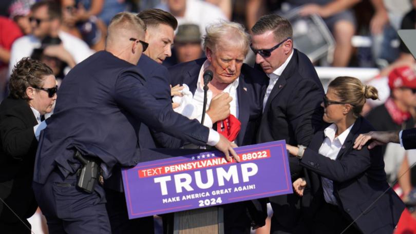 Security agents surround Donald Trump after the failed assasination attempt.