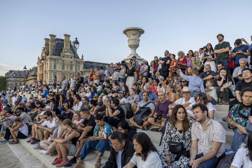 PARIS, FRANCE - JULY 28: PARIS, FRANCE - JULY 28: Visitors watch and take pictures of the Olympic cauldron (not seen) on day two of the Olympic Games Paris 2024 at on July 28, 2024 in Paris, France. (Photo by Maja Hitij/Getty Images)