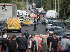 Members of the media gather as police and forensic officers attend the scene of a multiple stabbing attack in Southport, England. 