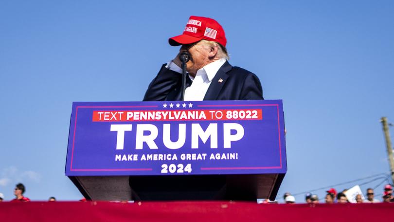 Former President Donald Trump reaches to touch his ear as he speaks at a campaign rally in Butler, Pa., on Saturday.