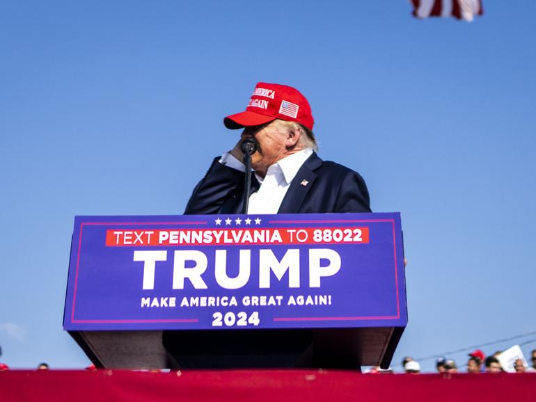 Former President Donald Trump reaches to touch his ear as he speaks at a campaign rally in Butler, Pa., on Saturday.