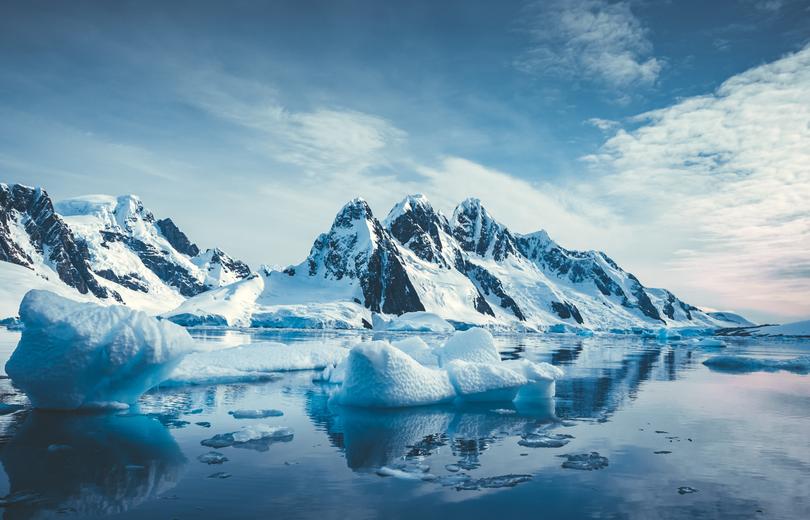 Blue Ice covered mountains in south polar ocean. Winter Antarctic landscape. 