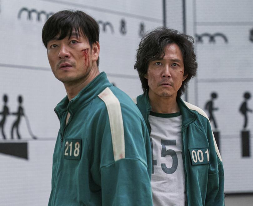 This image released by Netflix shows Lee Jung-jae, right, and Park Hae-soo in a scene from the Korean series "Squid Game."  (Netflix via AP)