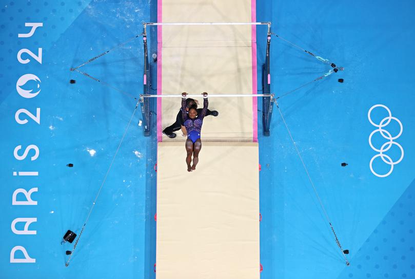 PARIS, FRANCE - AUGUST 01: (EDITORS NOTE: Image was captured using a robotic camera positioned above the field of play) Simone Biles of Team United States competes on the uneven bars during the Artistic Gymnastics Women's All-Around Final on day six of the Olympic Games Paris 2024 at Bercy Arena on August 01, 2024 in Paris, France. (Photo by Naomi Baker/Getty Images)